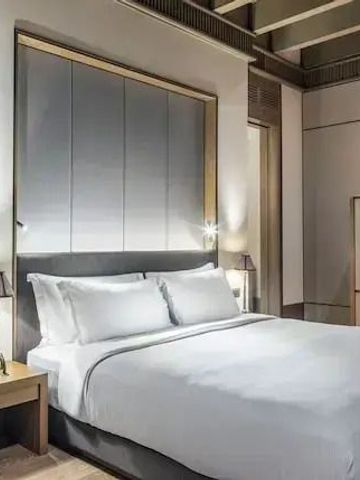 Großes, elegantes Schlafzimmer mit dezenter Beleuchtung und luxuriösem Bett