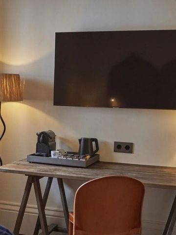 Eleganter Schreibtisch mit Lampe und Kaffeezubehör in einem Hotelzimmer