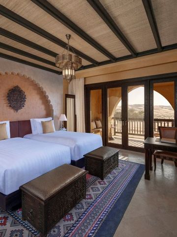 Zweibettzimmer mit traditionellem Dekor und Balkon mit Wüstenblick.
