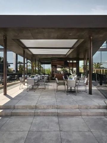 Eleganter Restaurantbereich im Freien mit stilvollem Mobiliar und Glasfassade