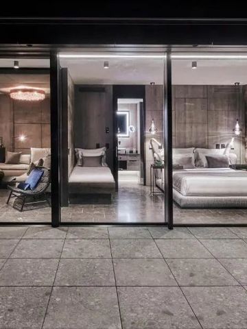 Luxuriöses Hotelzimmer mit Glasfront, gemütlichen Betten und stilvoller Einrichtung