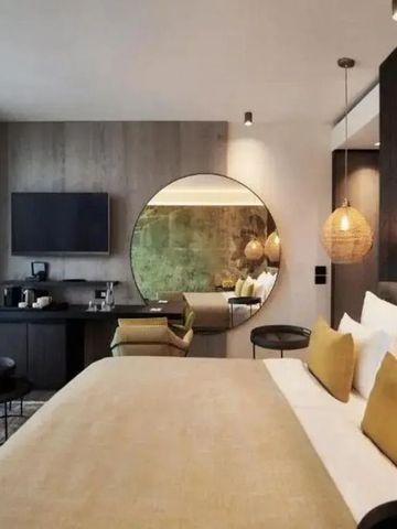 Luxuriöses Zimmer mit großem Bett, stilvoller Dekor und Spiegelwand