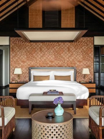 Elegante Suite mit warmen Farbtönen und Rattanmöbeln im Raffles Bali