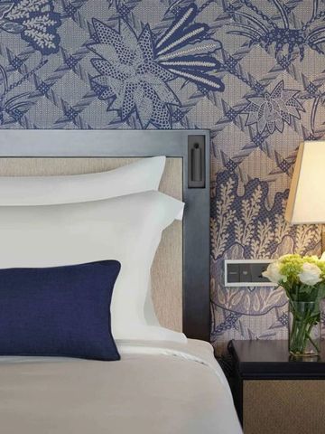 Elegantes Schlafzimmer mit luxuriösem Design und blumiger Tapete.