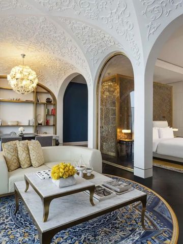 Luxuriöse Suite mit eleganter Deckenverzierung und komfortabler Sitzgruppe