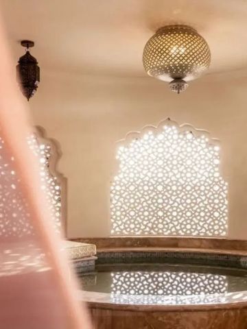 Traditionell gestaltetes Spa mit filigranen Fensterverzierungen und zentralem Wasserbecken