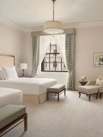 Elegantes Hotelzimmer mit zwei Betten und stilvollen Vorhängen