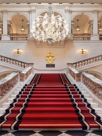 Prächtige Treppe mit rotem Teppich und Kronleuchter