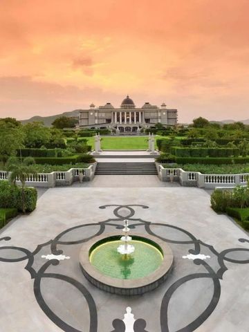 Eindrucksvoller Schlossstil-Garten mit Wasserfontäne und malerischem Sonnenuntergang