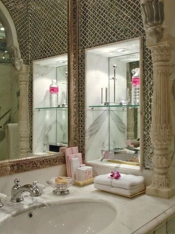 Luxuriöses Badezimmer mit kunstvollem Spiegel und eleganten Details
