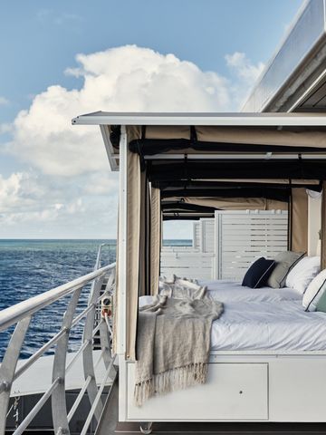 Reefsleep-Betten unter Baldachin auf dem Oberdeck des Pontons mit Blick aufs offene Meer