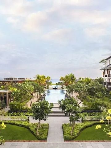 Blick auf den Hotelgarten mit Pool und Ozean im Hintergrund