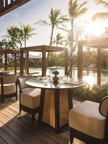 Stilvolle Outdoor-Terrasse mit Essbereich neben Pool in tropischer Umgebung