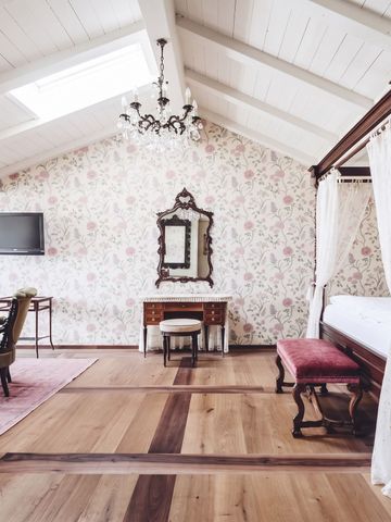 Luxuriöses Zimmer mit Himmelbett und floraler Tapete