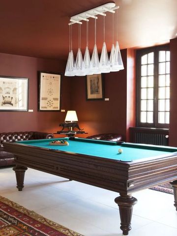 Billardraum mit Chesterfield-Sofa und kunstvollen Bildern