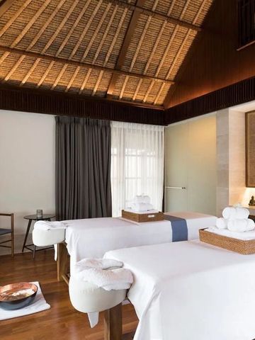 Zwei Massagetische in einem eleganten Spa-Raum mit warmem Holzdekor