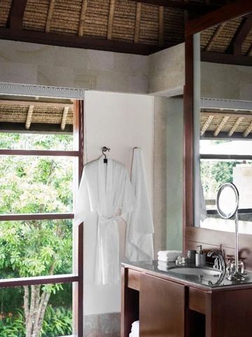 Elegantes Badezimmer mit hölzernen Akzenten und grünem Blick durch Fenster