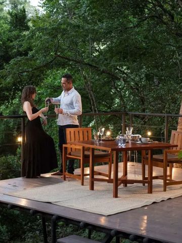 Paar genießt ein Abendessen auf einer Terrassenterrasse im Wald