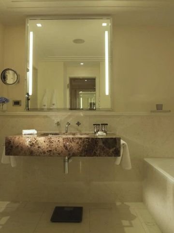 Modernes Badezimmer mit großem Spiegel und edlem Waschbecken.