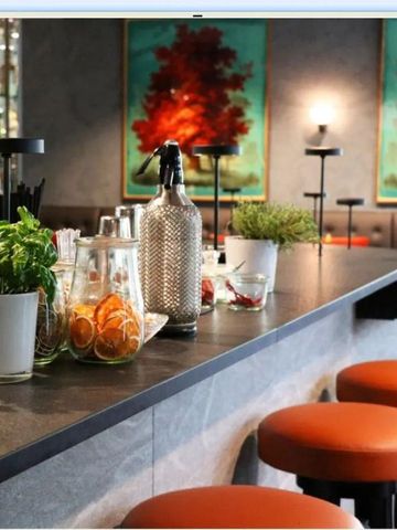 Stylische Hotelbar mit kunstvoller Dekoration und modernen Sitzgelegenheiten.