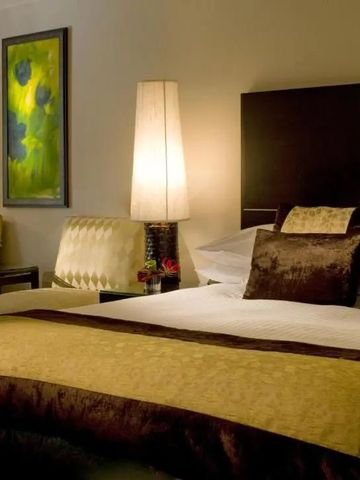 Luxuriöses Hotelzimmer mit elegantem Bett und stilvollem Kunstwerk