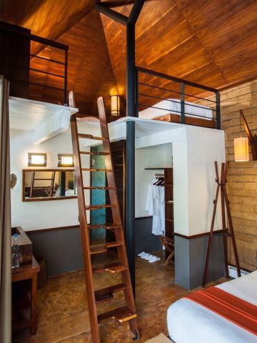 Loft-Stil Zimmer mit Holzelementen und Schlafbereich auf erhöhter Plattform