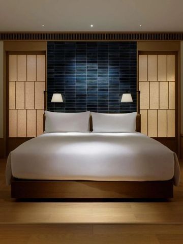 Modernes Hotelzimmer mit großem Doppelbett und traditioneller japanischer Ästhetik