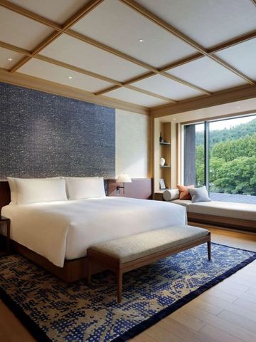 Luxuriöses Hotelzimmer mit großem Fenster und Blick auf die Natur