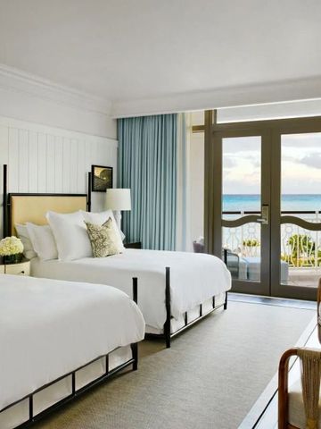 Elegantes Hotelzimmer mit zwei Doppelbetten und Blick auf das Meer.