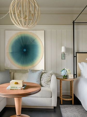 Luxuriöse Suite mit gemütlicher Sitzecke und modernem Kunstwerk an der Wand.