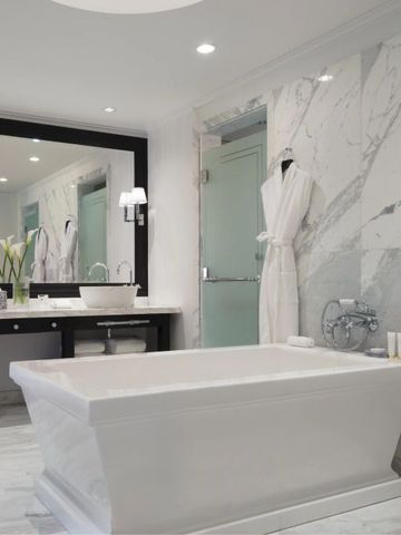 Luxuriöses Badezimmer mit freistehender Badewanne und Marmorwänden