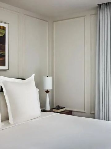 Minimalistisch gestaltetes Hotelzimmer mit dekorativer Kunst über dem Bett
