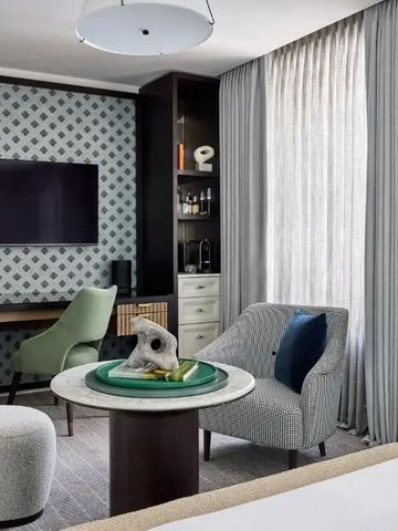 Elegantes Hotelzimmer mit modernem Dekor und komfortablen Sitzmöbeln und Arbeitstisch