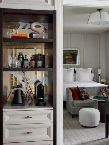 Luxuriöses Zimmer mit sichtbarer Minibar und Blick auf gemütliches Schlafzimmer
