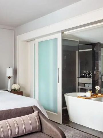 Luxuriöses Hotelzimmer mit großem Bett, Badewanne und modernem Design