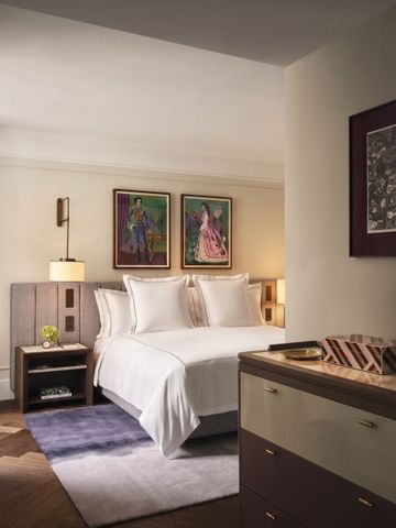 Elegantes Hotelzimmer mit Doppelbett und Kunstwerken an der Wand