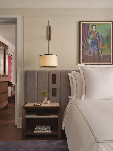 Detailansicht eines Hotelzimmers mit luxuriösem Bett und Kunstwerken