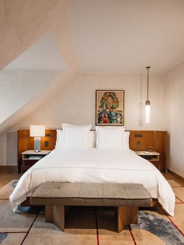 Geräumiges Dachzimmer mit großem Bett und moderner Dekoration