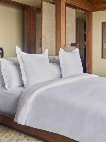Luxuriöses Hotelzimmer mit großem Bett und Holzelementen.
