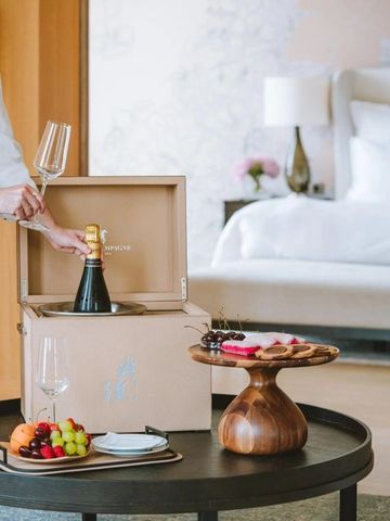 Sekt und Snacks auf einem Tisch in einem luxuriösen Hotelzimmer