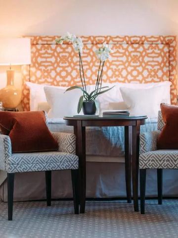Stilvolles Doppelzimmer mit dekorativer Kopfleiste und eleganten Sesseln