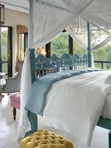 Helle Suite mit großem Himmelbett, Blick auf die Natur, elegante Dekoration.