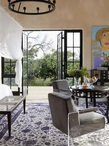 Geschmackvoll eingerichtetes Zimmer mit modernem Kunstwerk, Terrasse mit Gartenblick.