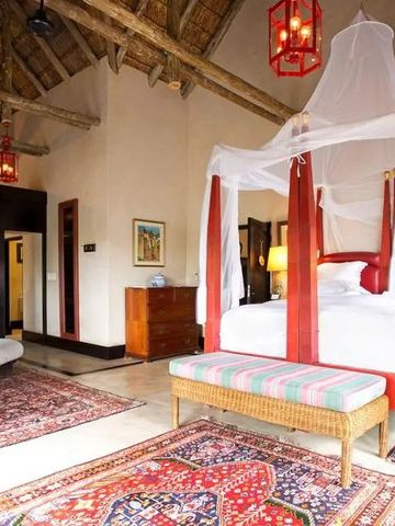 Charmante Suite mit traditionellem Himmelbett, warmen Farbtönen und feinen Teppichen.