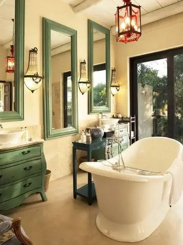 Helles Badezimmer mit freistehender Badewanne und grüner Kommode