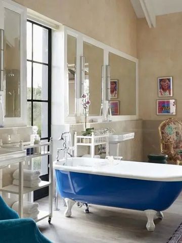 Badezimmer mit blauer Standbadewanne und eleganten Akzenten