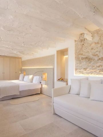 Großes Schlafzimmer mit rustikaler Wand und heller Einrichtung