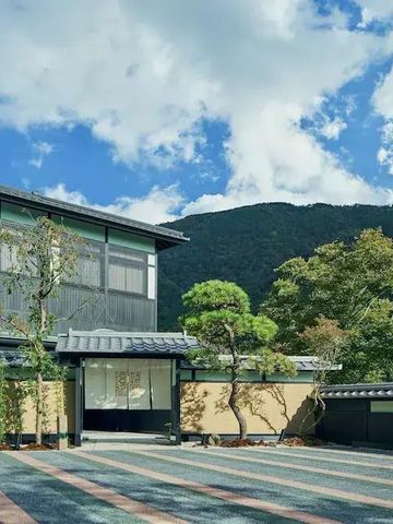Moderne Hotelarchitektur mit traditionellem japanischem Stil vor Bergkulisse.