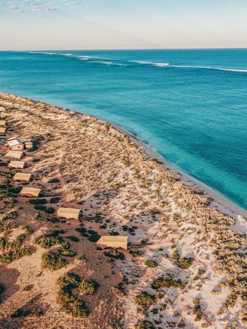 Zelte von Sal Salis in den Küstendünen des Cape Range National Park, daneben Strand und Riff