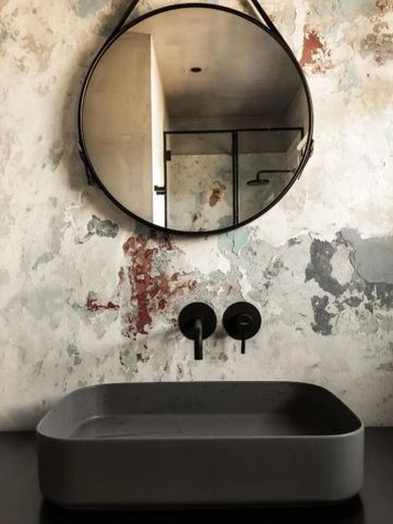 Stylisches Waschbecken mit rundem Spiegel und modernem Wasserhahn im San Canzian Hotel